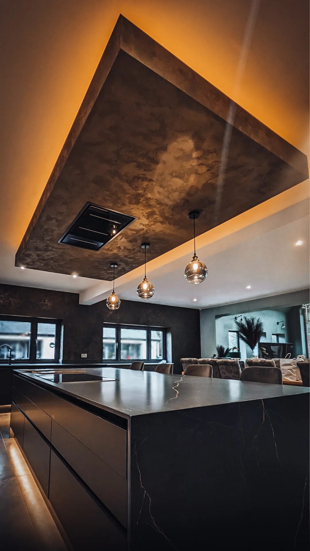Dark textured ceiling above a kitchen island with warm perimeter lighting
